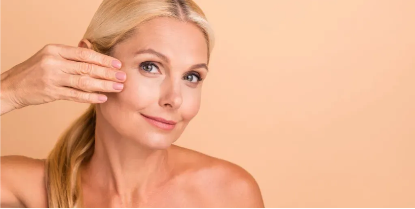 Woman with youthful complexion touching face